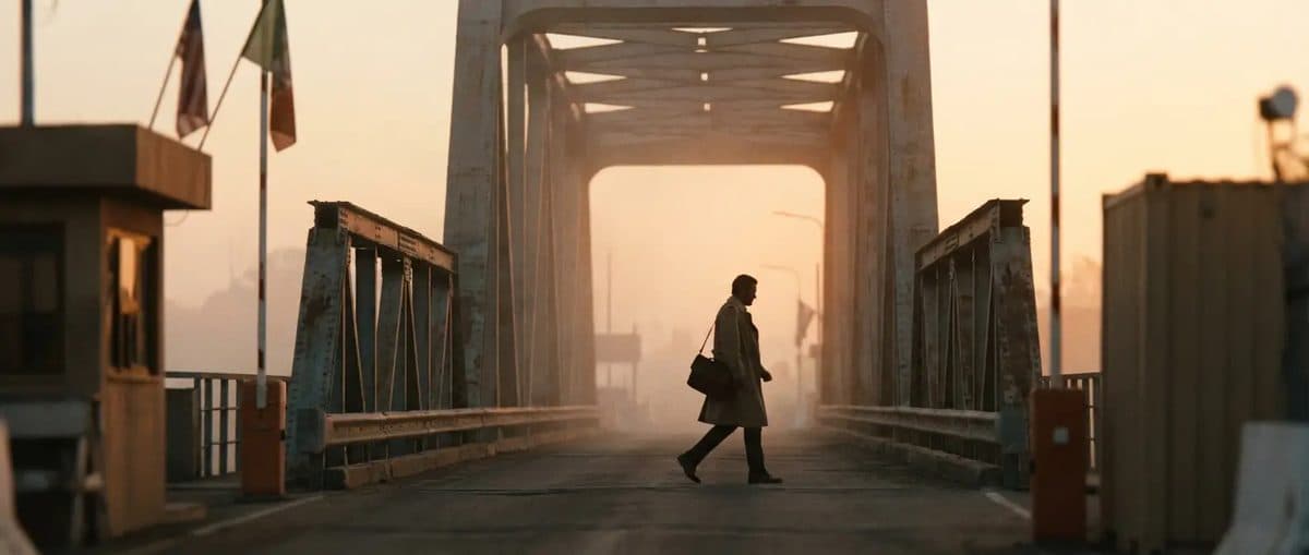 Professional crossing a border bridge at sunrise